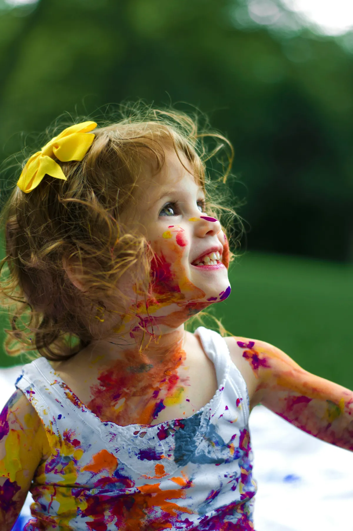 little girl covered in bright paints