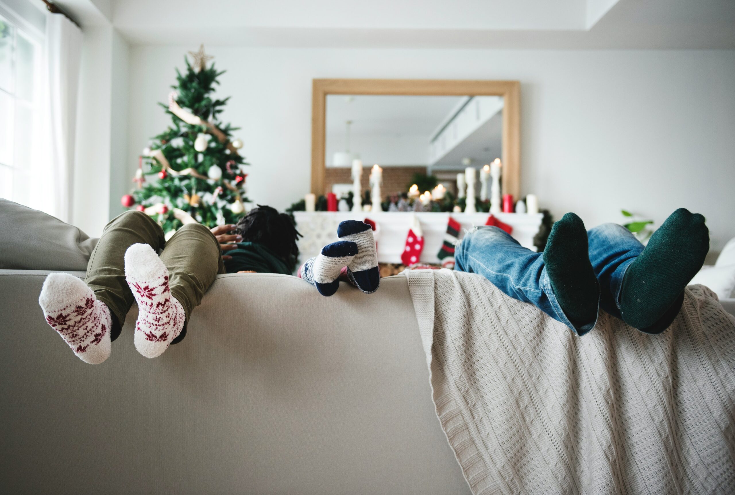 Christmas time and 3 sets of feet hanging over the couch